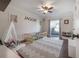 Stylized bedroom featuring a gray zigzag carpet, white teepee, modern bed, and ceiling fan at 7922 Spring Valley Dr, Tampa, FL 33615