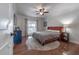 Bedroom with hardwood floors and a cozy bed, side table with lamp, dresser, and natural light from window at 7922 Spring Valley Dr, Tampa, FL 33615