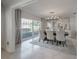 Modern dining room with stylish lighting, seating for eight, and a view of the living area at 7922 Spring Valley Dr, Tampa, FL 33615