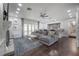 Open living room with fireplace, gray sectional, hardwood floors, and wet bar at 7922 Spring Valley Dr, Tampa, FL 33615