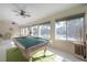 Sunroom with pool table and seating, featuring a wall of windows and tile floors at 7922 Spring Valley Dr, Tampa, FL 33615