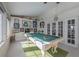 Sunroom with pool table, tile floors, and sports memorabilia at 7922 Spring Valley Dr, Tampa, FL 33615