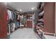 Spacious walk-in closet with custom built-in shelving and a wide selection of clothing and shoes at 7922 Spring Valley Dr, Tampa, FL 33615
