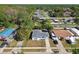 Aerial view of single-story home with fenced yard in a green neighborhood with mature trees and a nearby canal at 8003 W Powhatan Ave, Tampa, FL 33615