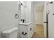 Bathroom with white vanity, toilet, black hardware, and a mirror, leading to a bedroom at 8003 W Powhatan Ave, Tampa, FL 33615