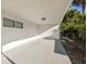 Attached carport featuring painted floor and walls, window, and entry to backyard at 8003 W Powhatan Ave, Tampa, FL 33615