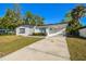 Well-maintained single-story home with a neat front lawn and a spacious carport area at 8003 W Powhatan Ave, Tampa, FL 33615