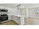 Bright kitchen featuring white cabinets, stainless steel appliances, and an island with quartz countertops at 8003 W Powhatan Ave, Tampa, FL 33615