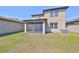 Large grassy backyard with a screened patio, attached to a light beige two-story home at 8306 Red Spruce Ave, Riverview, FL 33578