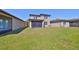 The spacious backyard with lush grass features a screened lanai attached to a two-story home at 8306 Red Spruce Ave, Riverview, FL 33578