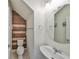 Stylish half bath with plank accent wall, modern fixtures, and round mirror at 8306 Red Spruce Ave, Riverview, FL 33578