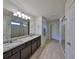 Spacious bathroom featuring a double vanity, tiled floors, and a glass-enclosed shower at 8306 Red Spruce Ave, Riverview, FL 33578