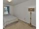Carpeted bedroom with a window, stylish floor lamp, and neutral walls at 8306 Red Spruce Ave, Riverview, FL 33578