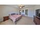 Carpeted bedroom featuring a ceiling fan, access to the hallway, and a neutral color scheme at 8306 Red Spruce Ave, Riverview, FL 33578