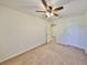 Bright carpeted bedroom with ceiling fan and views into the hallway at 8306 Red Spruce Ave, Riverview, FL 33578
