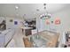 Bright dining area featuring a glass-topped table and modern chandelier, open to the kitchen with granite counters at 8306 Red Spruce Ave, Riverview, FL 33578