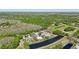 An aerial view of houses in a neighborhood, with green lawns, trees, and a lake at 954 Cobblestone Ln, Tarpon Springs, FL 34688