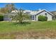 Backyard view showcasing the screened-in pool, landscaping, and well-kept yard at 954 Cobblestone Ln, Tarpon Springs, FL 34688
