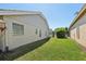 Spacious backyard with lush green lawn and block windows at 954 Cobblestone Ln, Tarpon Springs, FL 34688