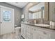 Bathroom features a double sink vanity, framed mirror, and wood tile flooring at 954 Cobblestone Ln, Tarpon Springs, FL 34688