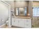 Bright bathroom featuring a spacious vanity with white cabinets and a decorative framed mirror at 954 Cobblestone Ln, Tarpon Springs, FL 34688