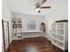 Bright bedroom with hardwood floors, ceiling fan, and custom built in shelving at 954 Cobblestone Ln, Tarpon Springs, FL 34688