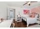 Bedroom shows a metal frame bed, crown molding, stylish decor and access to a hallway at 954 Cobblestone Ln, Tarpon Springs, FL 34688