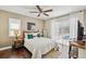 Modern bedroom features hardwood floors, white bedding, neutral decor, and a large window with pool views at 954 Cobblestone Ln, Tarpon Springs, FL 34688