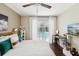 Bright bedroom features hardwood floors, ceiling fan, a work desk and a relaxing view of the pool at 954 Cobblestone Ln, Tarpon Springs, FL 34688