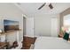 Bedroom showcases hardwood floors, crown molding, and a wall-mounted TV above a modern, decorative fireplace at 954 Cobblestone Ln, Tarpon Springs, FL 34688