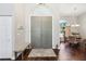 Inviting foyer with gray double doors, bench seating, and rich wood floors at 954 Cobblestone Ln, Tarpon Springs, FL 34688