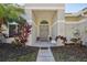The front entrance is adorned with decorative floral wreaths and features a walkway leading to the double front doors at 954 Cobblestone Ln, Tarpon Springs, FL 34688