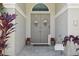 The entrance features double doors with floral wreaths, potted plants, and a stone-paved entryway at 954 Cobblestone Ln, Tarpon Springs, FL 34688