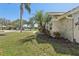 Well-manicured front yard featuring lush landscaping and palm trees on a sunny day at 954 Cobblestone Ln, Tarpon Springs, FL 34688