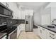 Modern kitchen with stainless steel appliances, black countertops and contrasting white cabinets at 954 Cobblestone Ln, Tarpon Springs, FL 34688