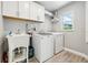 Bright laundry room with white cabinetry, sink, washer, and dryer at 954 Cobblestone Ln, Tarpon Springs, FL 34688