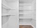 Walk-in closet with bright white walls, wood floors, and multiple shelves for organized storage at 971 Mcfarland St, Dunedin, FL 34698