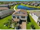 Aerial perspective of a well-kept two-story home with a manicured lawn and brick driveway at 10072 Sage Creek Dr, Ruskin, FL 33573