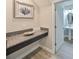 Bright bathroom featuring granite counters, modern sink and vanity, plus stylish wood-look tile flooring at 10072 Sage Creek Dr, Sun City Center, FL 33573