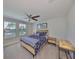 Bedroom featuring a patterned bedspread, wooden frame, neutral walls, a ceiling fan and natural lighting at 10072 Sage Creek Dr, Ruskin, FL 33573