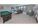 Spacious game room with a pool table, cozy seating, and plenty of natural light from the windows at 10072 Sage Creek Dr, Ruskin, FL 33573