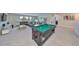 Open-concept game room features a pool table, comfortable seating, a media center and bright, natural light at 10072 Sage Creek Dr, Ruskin, FL 33573