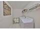 Bright laundry room with white washer and dryer, storage shelves, and modern decor at 10072 Sage Creek Dr, Ruskin, FL 33573