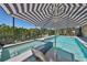 Relaxing pool and spa area with a striped umbrella and view of the water at 10072 Sage Creek Dr, Ruskin, FL 33573