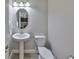 Charming powder room featuring a pedestal sink, modern lighting, and neutral decor at 10072 Sage Creek Dr, Ruskin, FL 33573