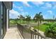 A balcony overlooks a manicured golf course with lush green grass, mature trees, and blue skies at 10161 Eagle Preserve Dr, Englewood, FL 34224