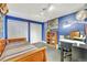Blue bedroom with a bed, bookshelf, work area and large painting of a tree at 1108 W Charter St, Tampa, FL 33602