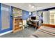 Blue bedroom with a bed, bookshelf, work area and large painting of a tree at 1108 W Charter St, Tampa, FL 33602