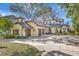 Elegant home features a charming exterior with a turret, attached garage, and driveway, all set amidst lush landscaping at 1108 W Charter St, Tampa, FL 33602