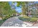 Charming home showcasing an expansive driveway, verdant lawns, and mature trees under a clear sky at 1108 W Charter St, Tampa, FL 33602